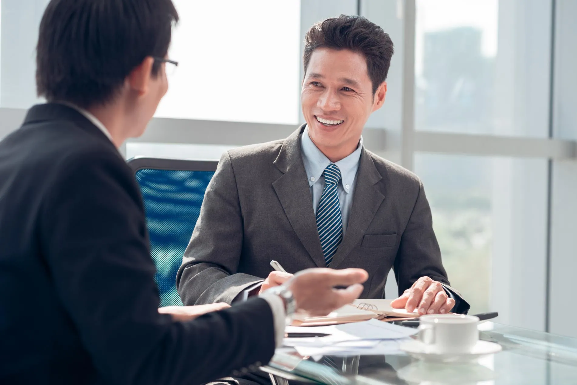 Two men at a table discussing a contract