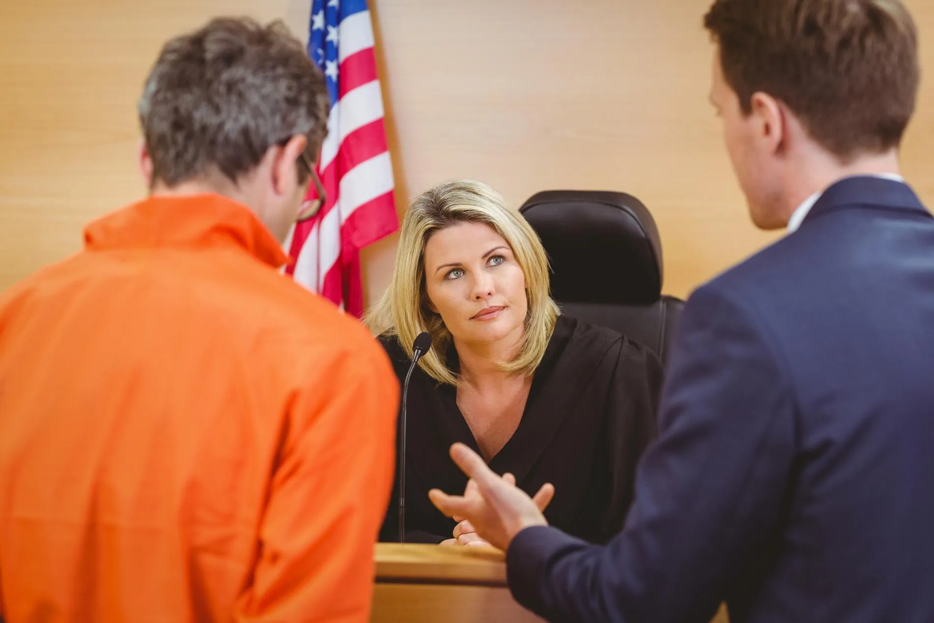 A defendant in a courtroom with his lawyer in front of a judge