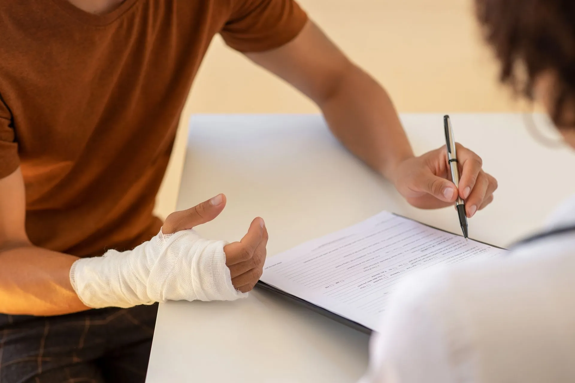 An injured hand with a fracture signing a document