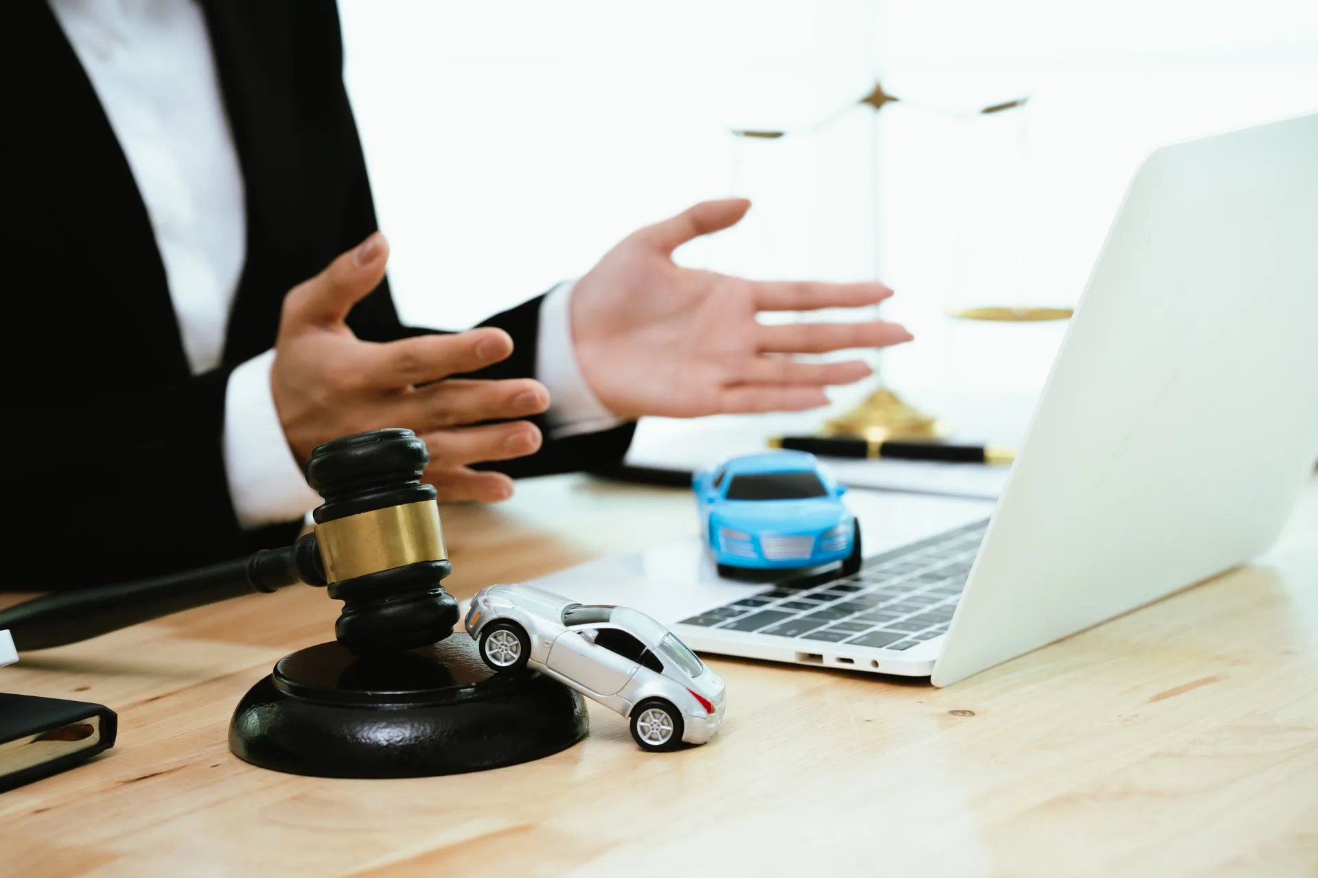 Lawyer with gavel and toy car, showcasing personal injury law services for auto accident cases.