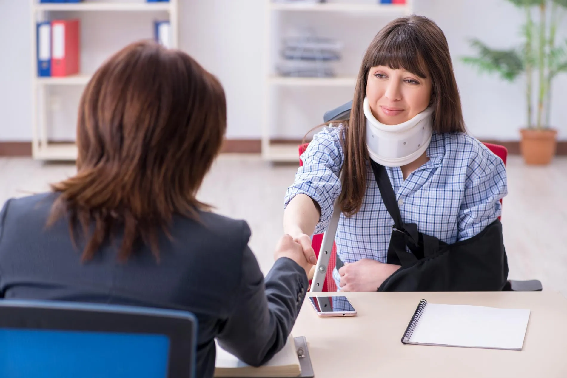 A disabled woman shaking hands with a lawyer