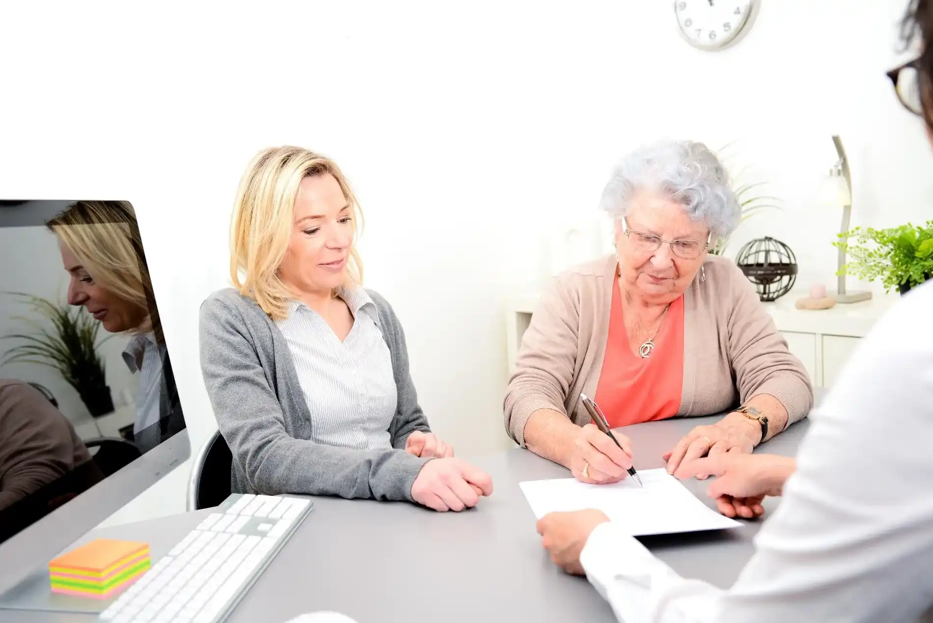 An Elderly lady signing a document with her lawyer
